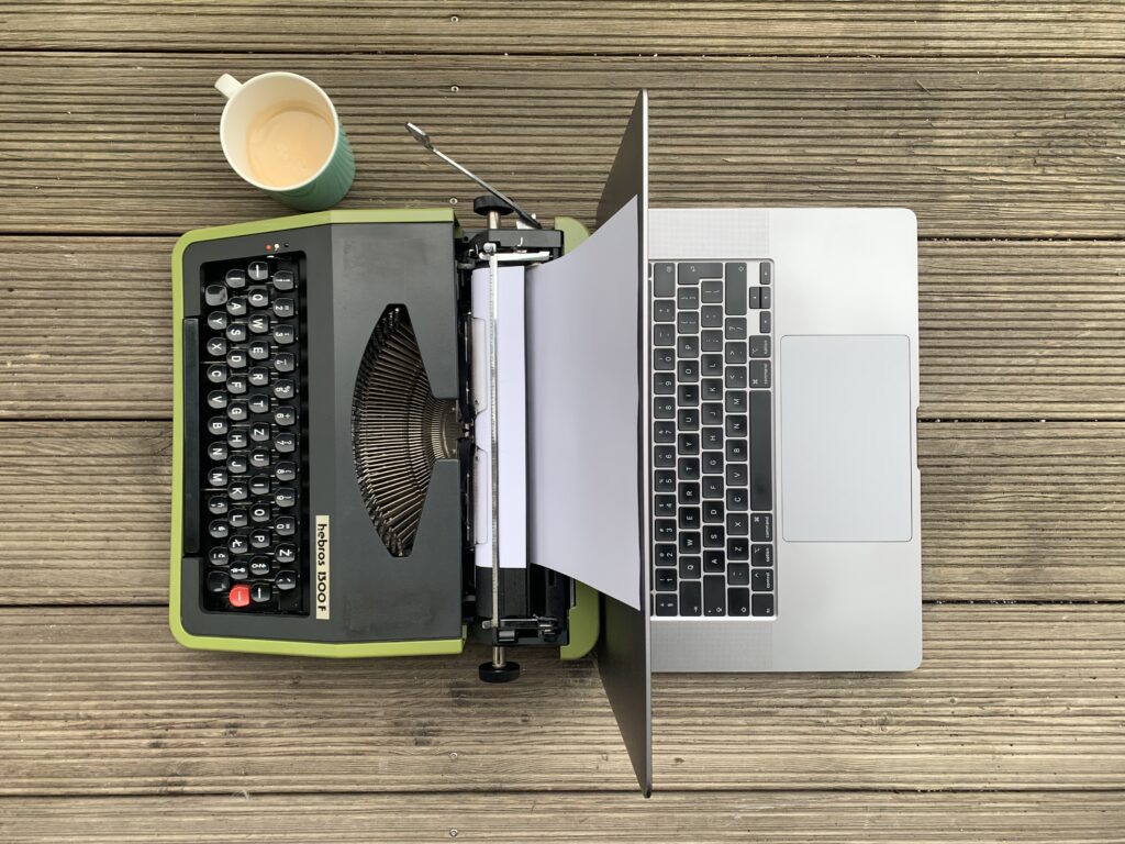 Kawa, maszyna do pisania i laptop